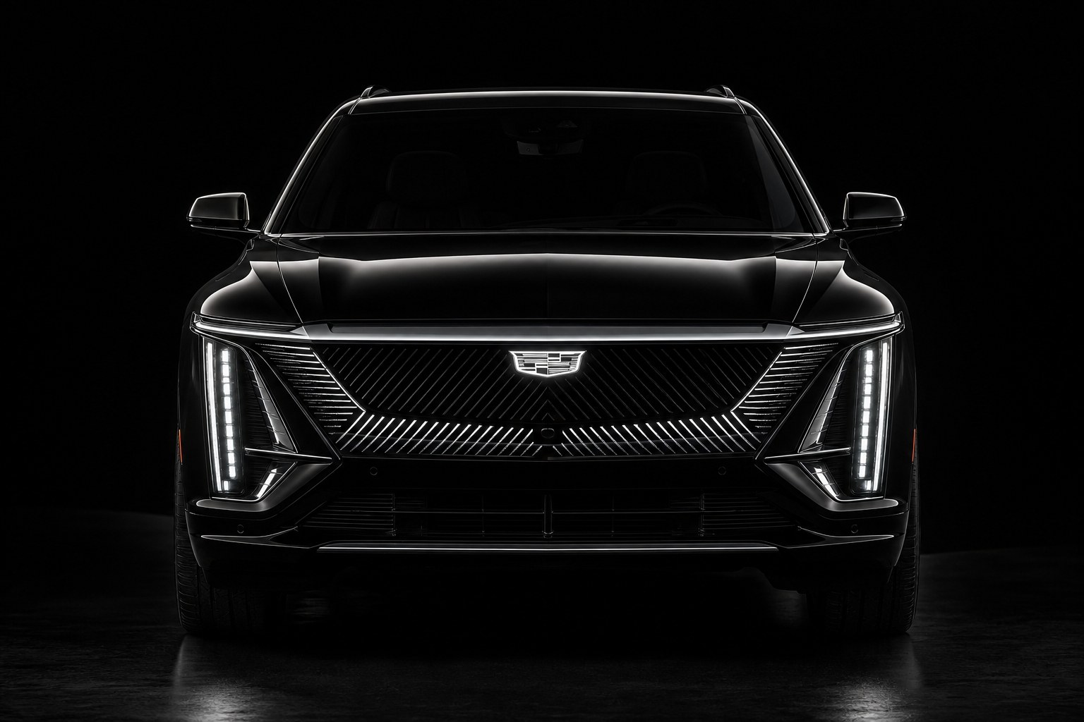 The front of a black Cadillac Lyriq in studio light: hood, illuminated grille shield, vertical LED headlamps and bumper, the panels a collision repair replaces