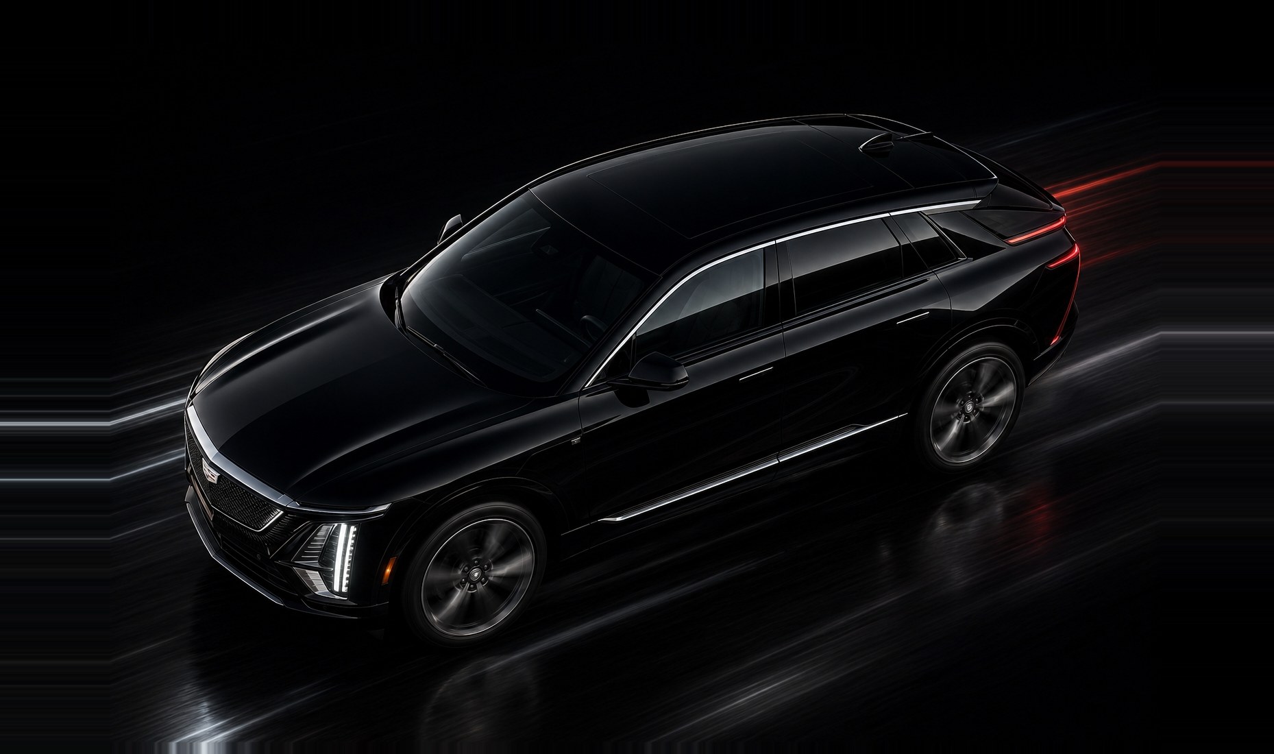 A black Cadillac Lyriq under studio light, seen from above and ahead of the front wing