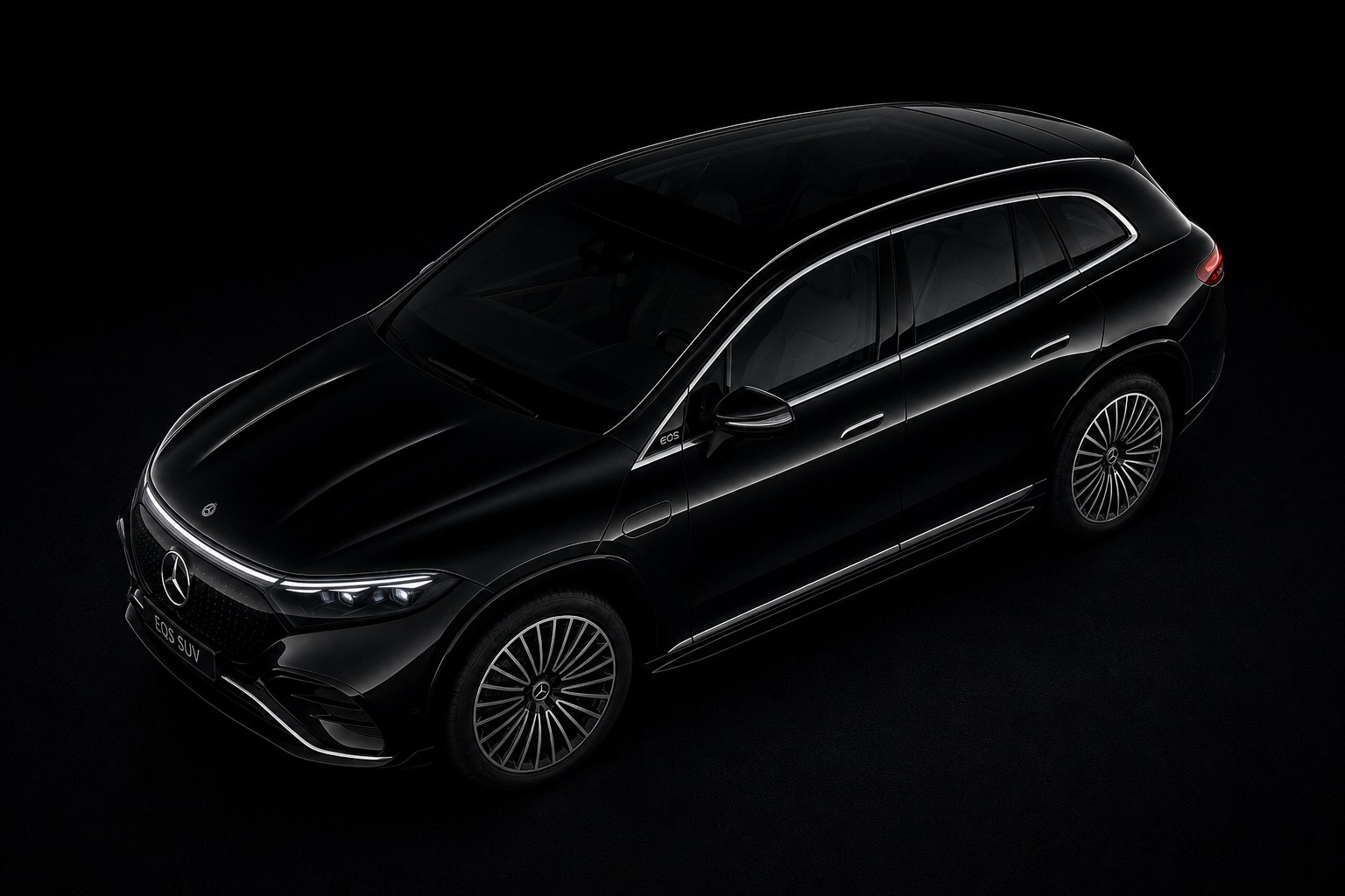 A black Mercedes-Benz EQS SUV under studio light, seen three-quarter from above