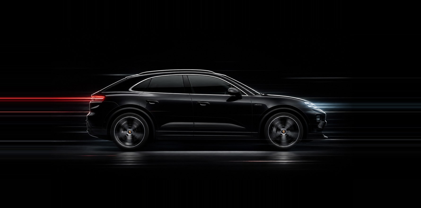 A black Porsche Macan Electric in profile against a dark backdrop, the full length of the body a calibration has to be measured against