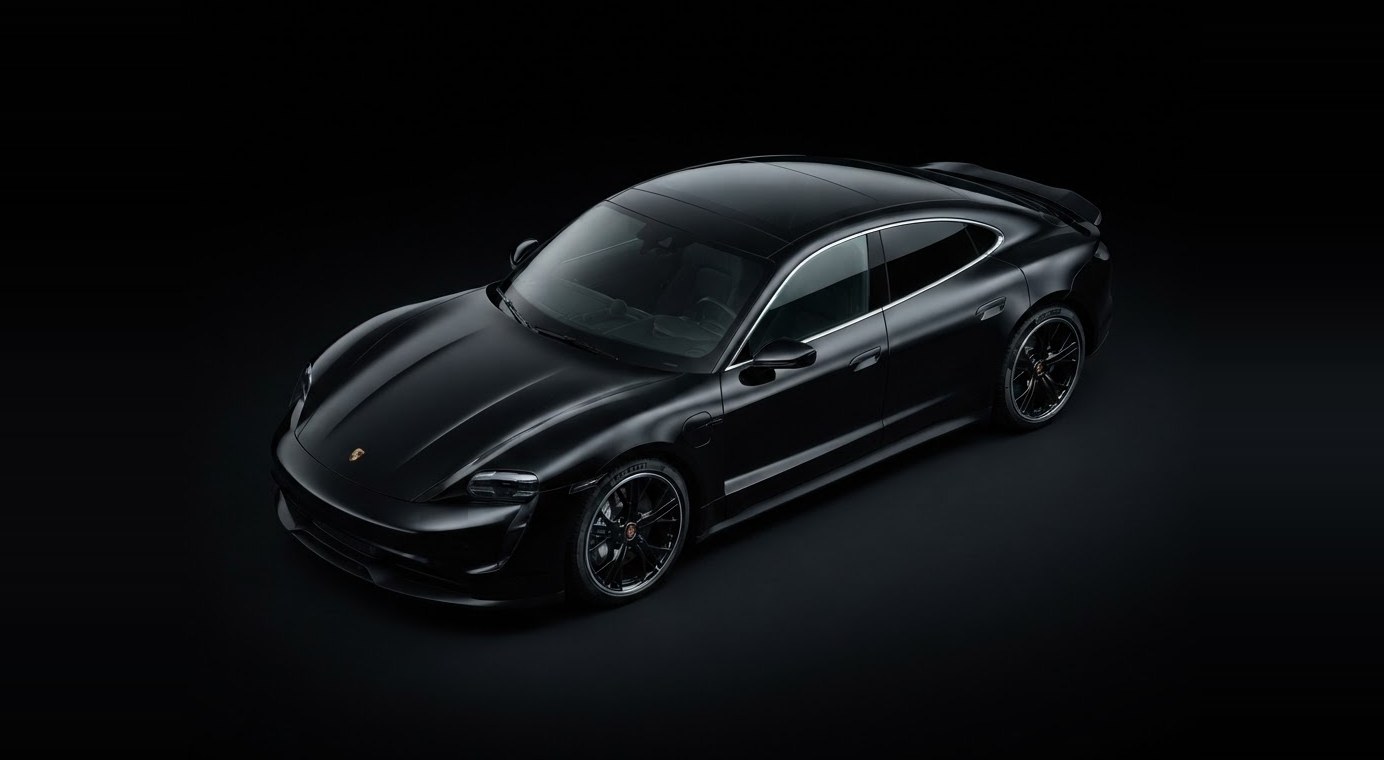 A black Porsche Taycan under studio light, seen from above and ahead of the front wing